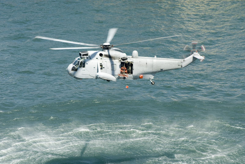 a seaking helicopter performing a rescue over water