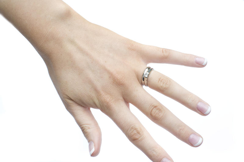 a girls hand wearing a platinum wedding rings