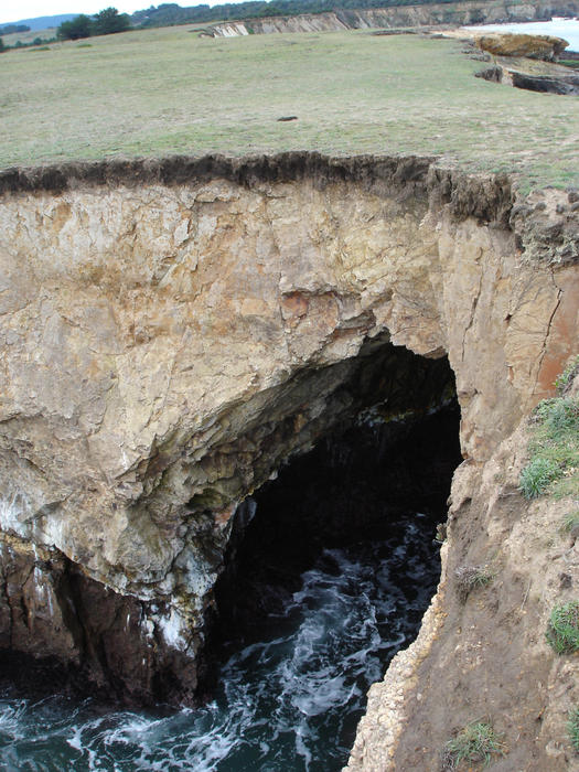 waves eroding an arch into the coast