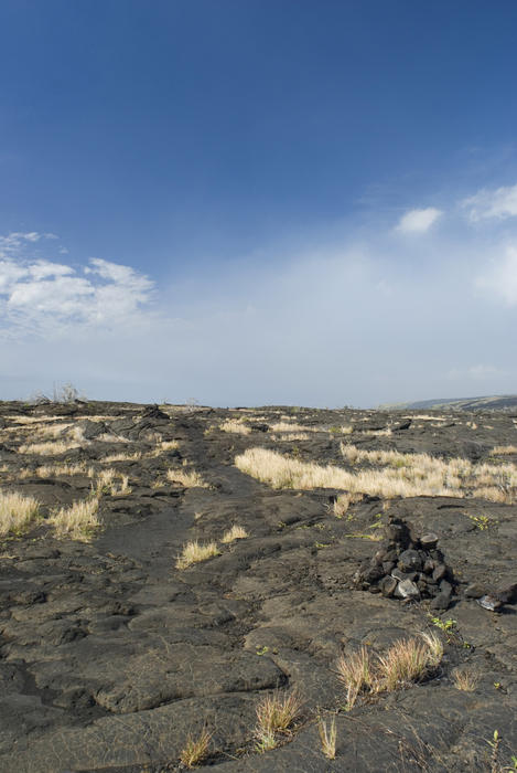 black stone pavement at pu'u loa, blue sky space for text