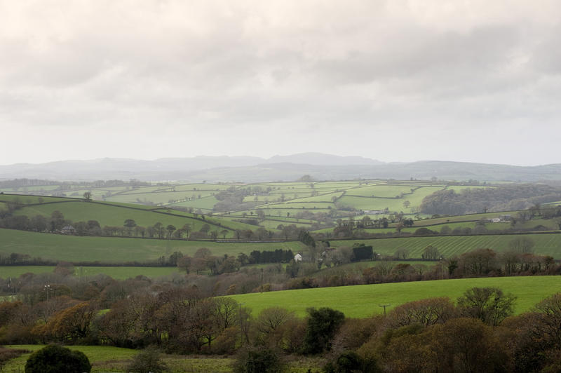 View across the lush green rolling hills of the Cornish countryside on a misty day