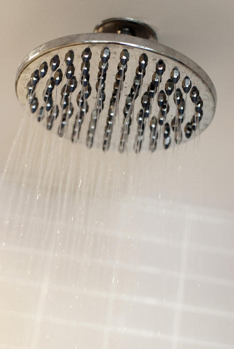 Water droplets falling from a modern shower head while enjoying a nice refreshing shower