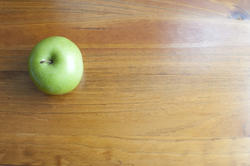 7025   Green apple on school desk