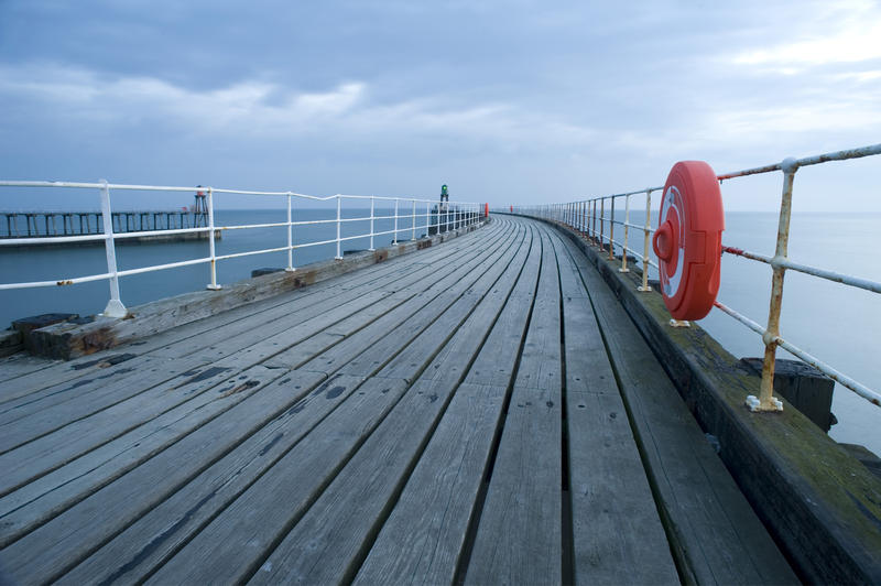 a brightly colored lifering and case on the side of a pier