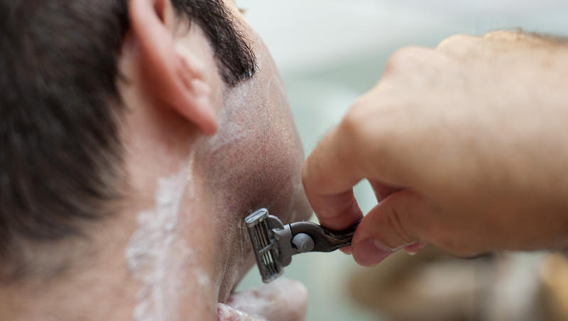 Close up shot of a man who is shaving himself