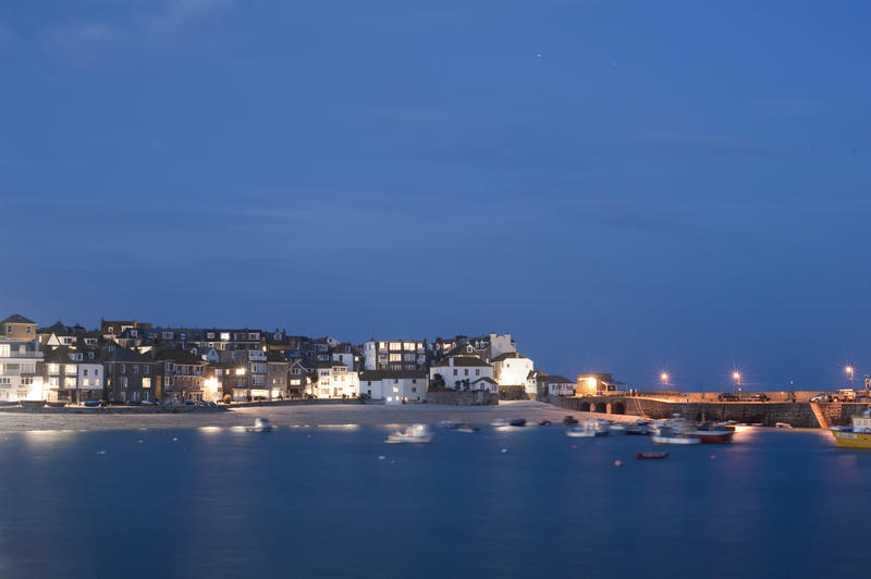 Night time shot taken from the sea of the illuminated buildings along the harbour of St Ives, Cornwall, UK