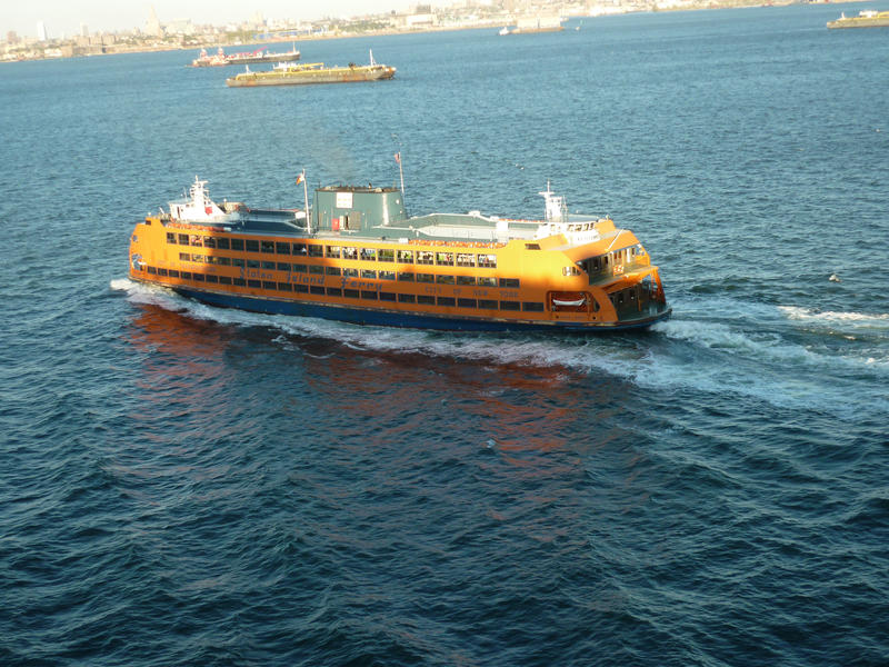 The yellow Staten Island passenger ferry mid ocean as it makes the commute to Manhattan, New York