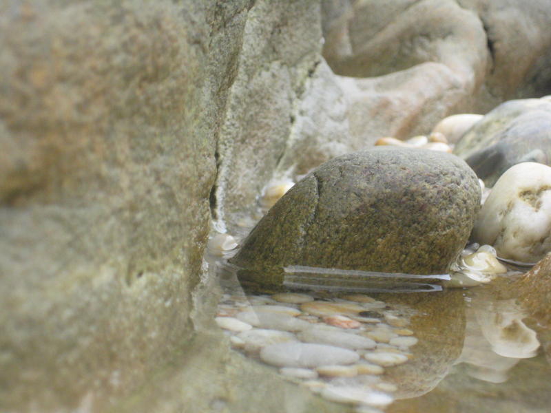 <p>&nbsp;Stone and water on the beach</p>