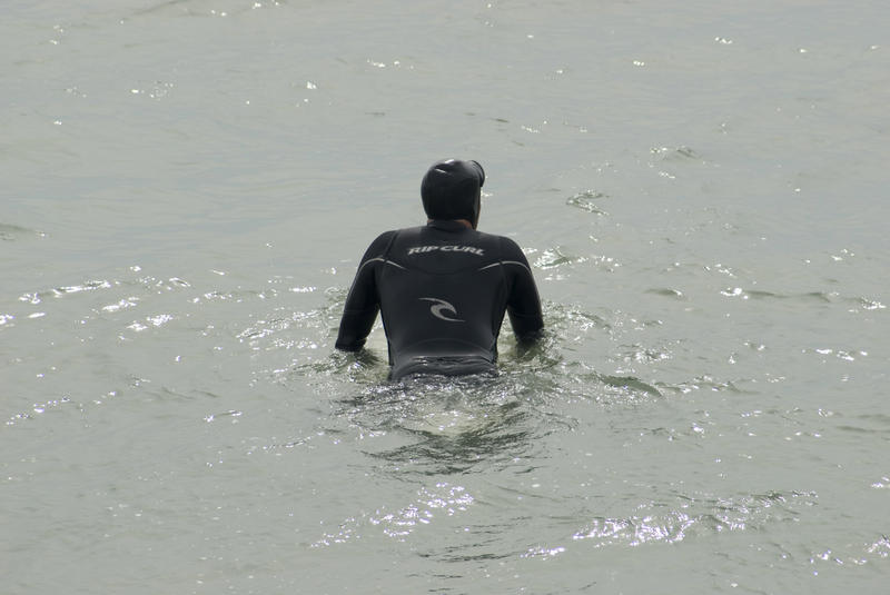 a surfer in the cold pacific waters off the coast of california - not model released