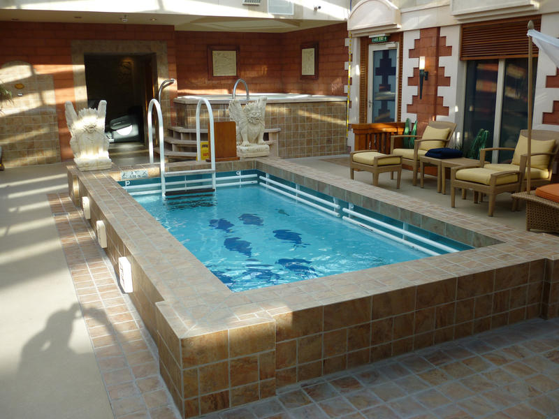 Small inviting blue undercover swimming pool or splash pool with comfortable recliner seats