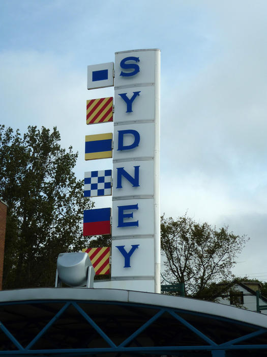 Sydney signpost, Nova Scotia, Canada mounted on top of a building welcoming people to the city