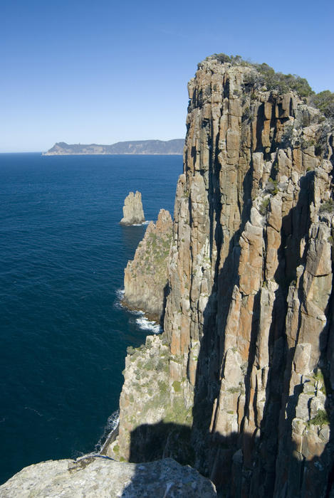rocky cliffs off the coast of cape hauy with cape pillar in the background