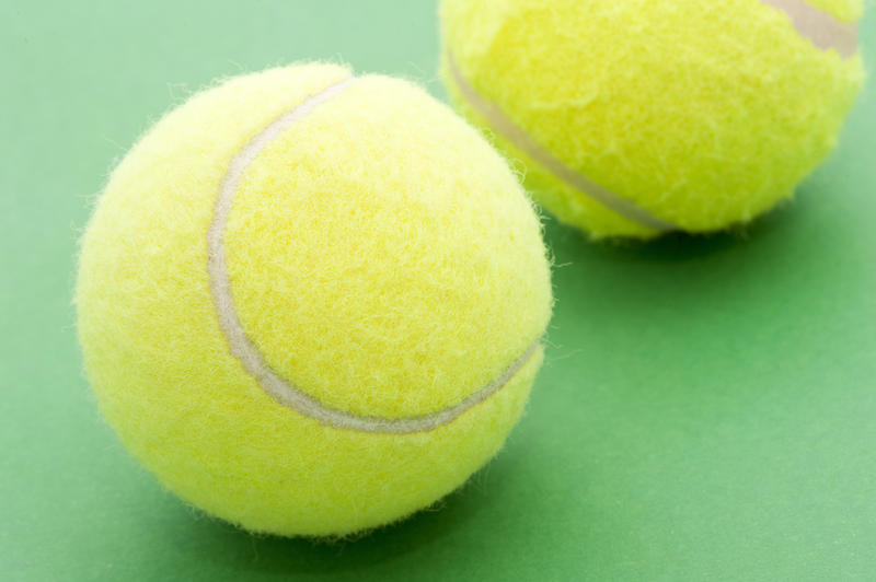 two tennis balls on a green background