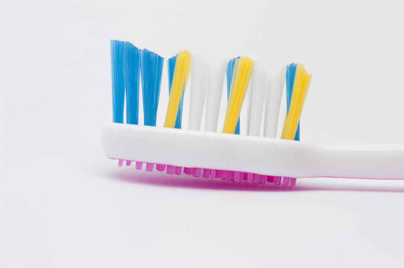 Close-up view of the bristles of a colorful toothbrush on white background