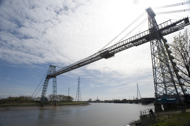 The tall steel span of the historic Transporter Bridge, Newport, Wales which relies on a gondola to ferry cars and people across the River Usk because the banks are too low for a conventional bridge