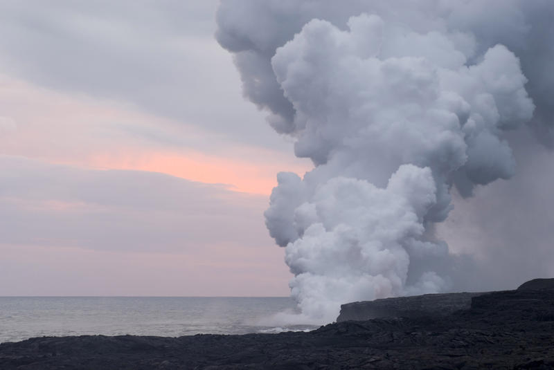 Volcanic smoke and steam cloud created where a hot lava flow meets the cold ocean, Big Island Hawaii