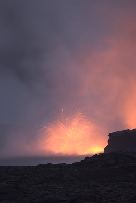 amazing fiery view of lava entering the ocean and spewing clouds of steam, near Kalapana, Hawaiis Big Island