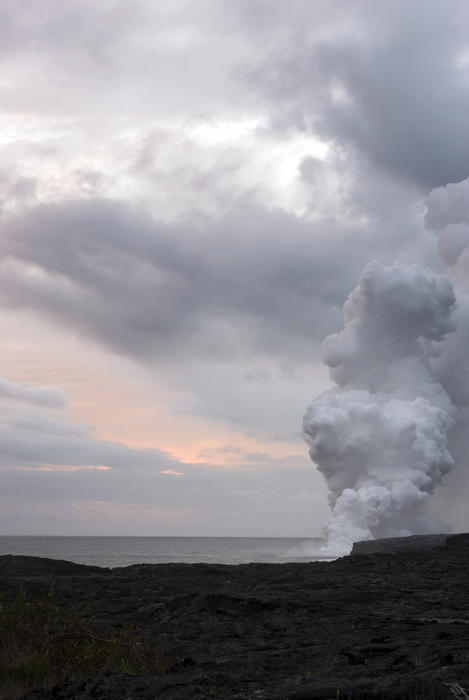 clouds of smoke and hot gas as lava from a subterranean lava tube enters the ocean