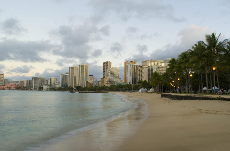 looking along an empty beach in the early morning, waikiki beach honolulu, hawaii