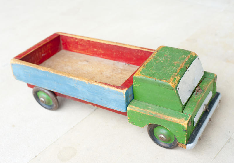 Worn simple wooden vintage toy truck, a reminder of a past Christmas, over white