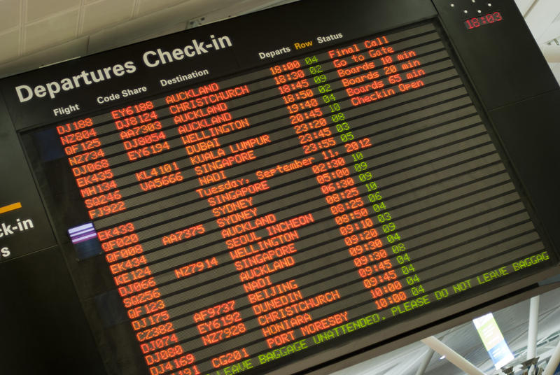 Close up of a Departures Check in board at an airport terminal giving information for various flights and airlines and their checking in procedures and times