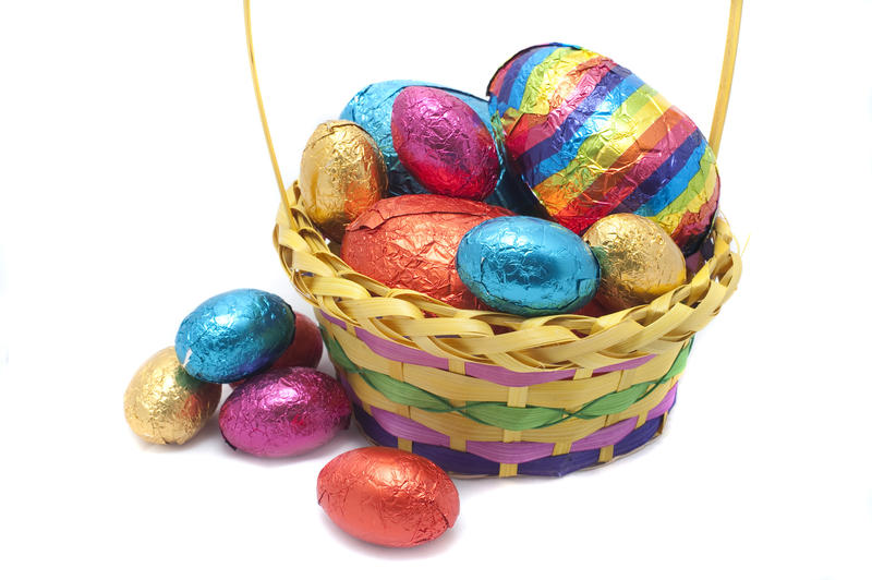 Decorative basket of Easter eggs in assorted sizes and colours on a white studio background