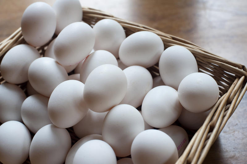 Wicker basket filled with farm fresh white chicken eggs at a market for a healthy cooking ingredient and breakfast