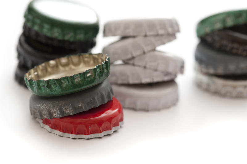 Still Life Close Up of Stacks of Colorful Bottle Caps on White Background with Copy Space