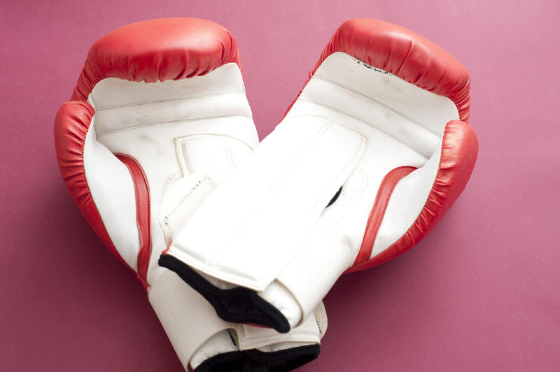 Close up Pair of Red and White Boxing Gloves for Fitness Workout Isolated on Dark Pink Background