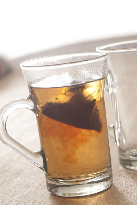 Transparent glasses with brewing hot black tea. Daylight