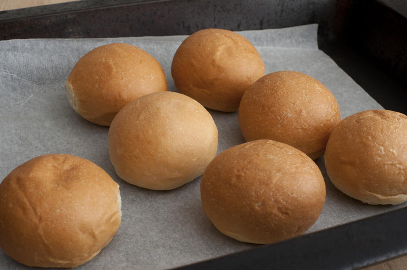 Close Up of Freshly Baked Brioche Bread Rolls on Parchment Paper Lined Pan