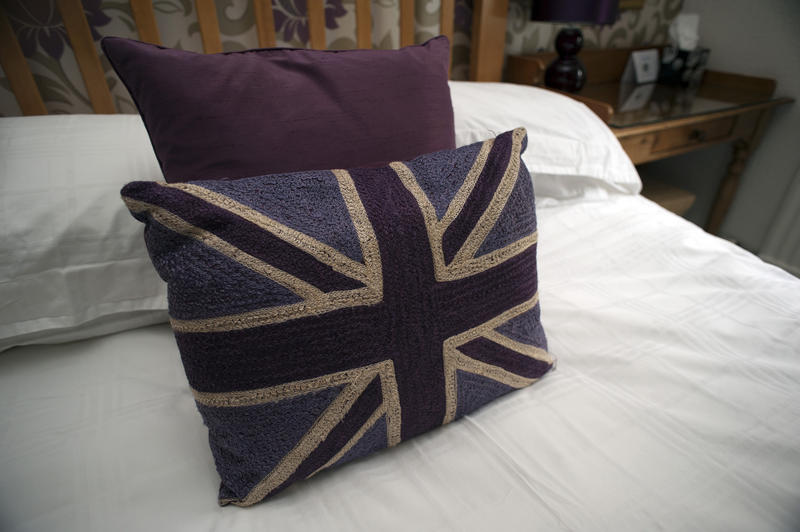 Britain themed bedroom with a Union Jack pattern pillow of the national flag on white bed linen