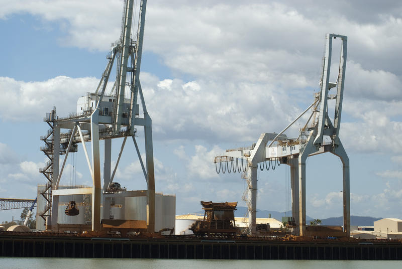 Large industrial cranes at a cargo wharf at a port or harbor for loading and off-loading freight off ships