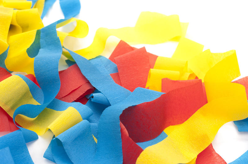 Close up Red, Blue and Yellow Celebration Streamers on Top of a White Table