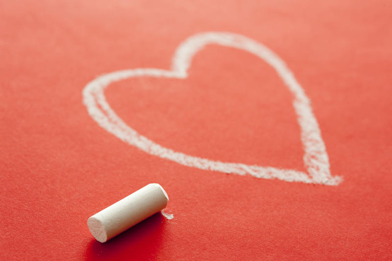 Still Life of Piece of White Chalk Beside Heart Drawn on Red Background - Love Concept Image
