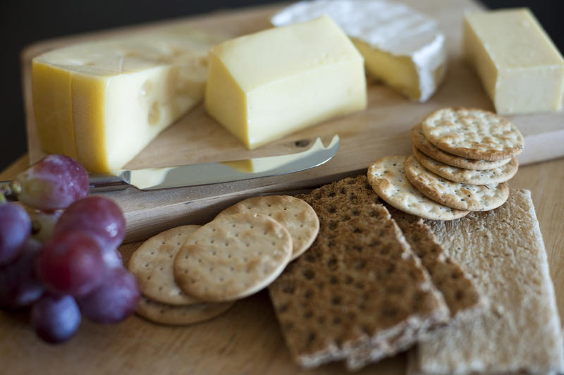 Assorted varieties of cheese on a cheeseboard served with crackers as an appetizer to a meal