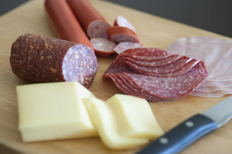 Wholesome German breakfast for a good start to the day with sliced cheese, salami and ham on a chopping board