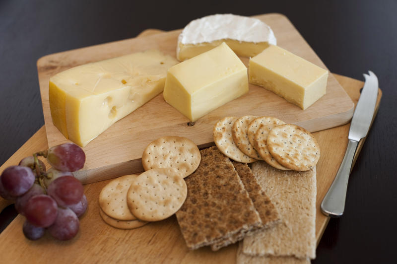 Cheese platter of assorted cheeses served with crispbread, wheat crackers, water biscuits and grapes