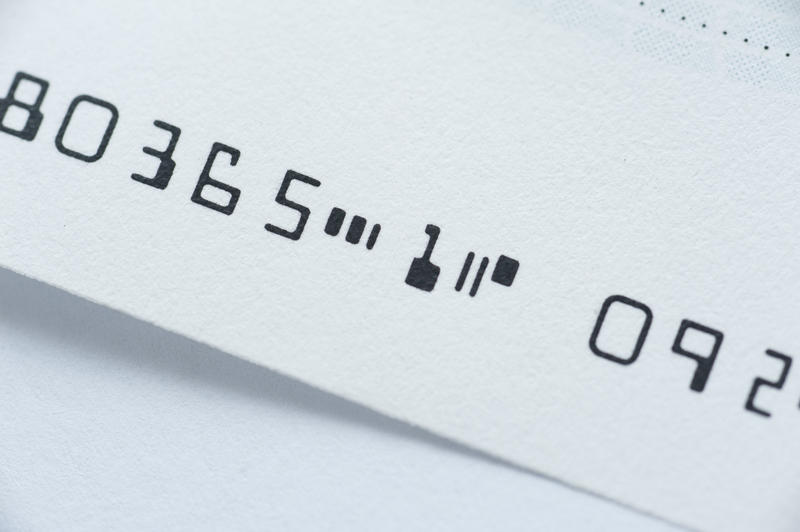 Close up Electronic Digital Cheque Numbers in Black on Top of White Table