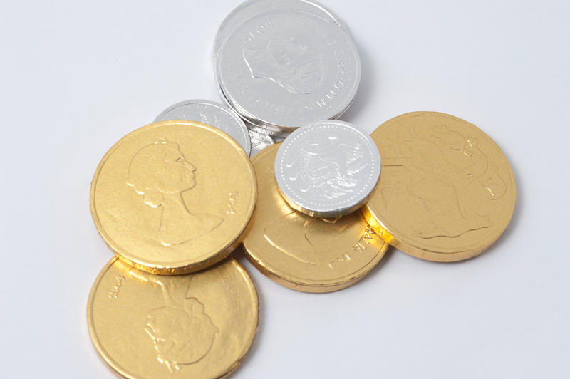 Chocolate gold and silver foil wrapped replica coins or money bearing an imprint of a queens head for a festive treat and table decoration