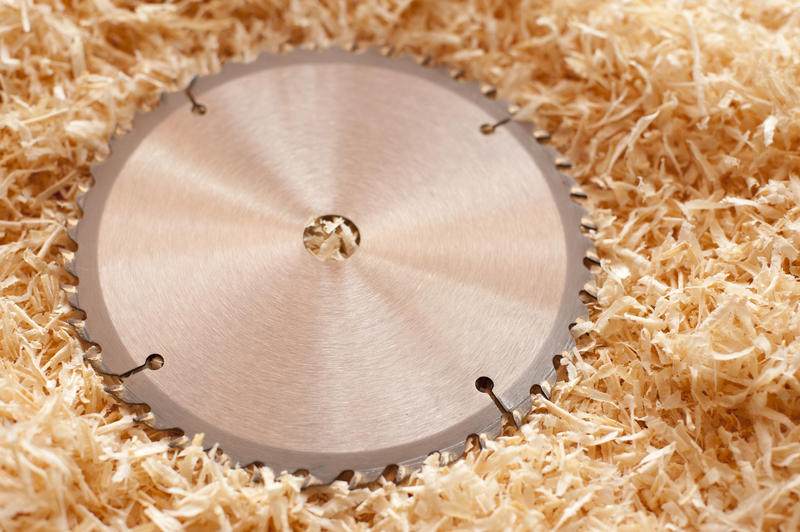 Circular saw blade or wheel lying on a bed of fresh wood shavings in a carpentry workshop in a DIY and renovation concept