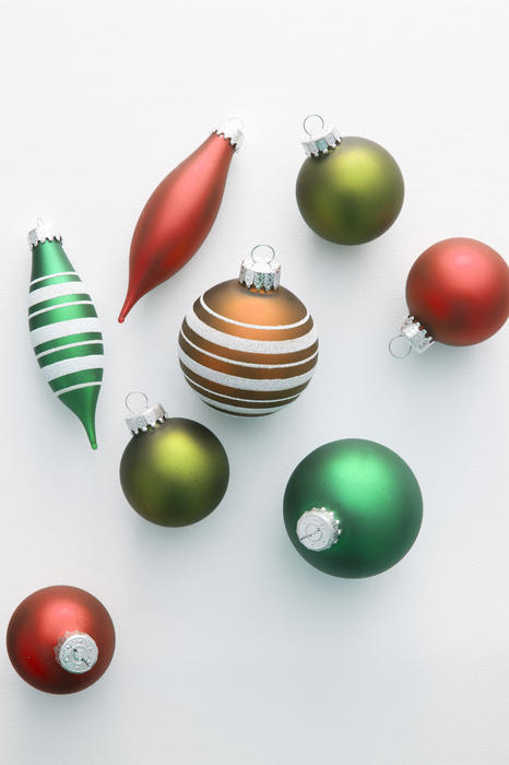 Colorful selection of Christmas ornaments scattered on a grey background with copy-space for your seasonal greeting