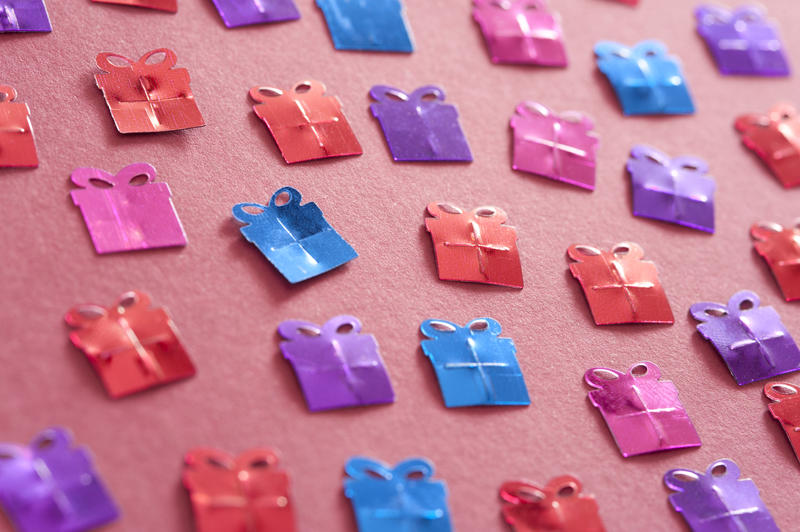 Seamless Pattern of Colored Gift Shaped Confetti on a Red Table in Close up