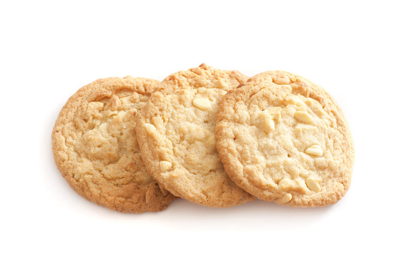 Three golden fresh crunchy nut cookies arranged in an overlapping line on a white background