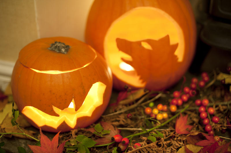 a cosy halloween fireside lantern display with seasonal berry wreath alongside