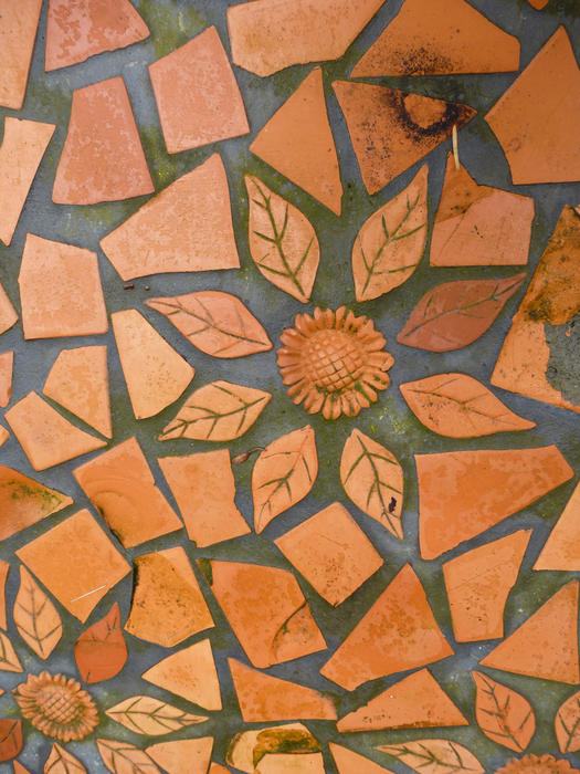 Full Frame Image of Terracotta Tiles in Irregular Shapes with Flower and Leaf Designs Embedded in Abstract Paving, Ideal for Backgrounds