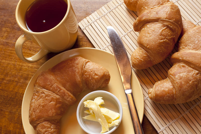 Delicious continental breakfast with freshly baked croissants and a mug of black espresso coffee, view from above