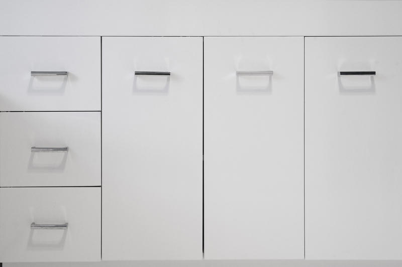Simple white kitchen cabinets with cupboards and a row of drawers for storage