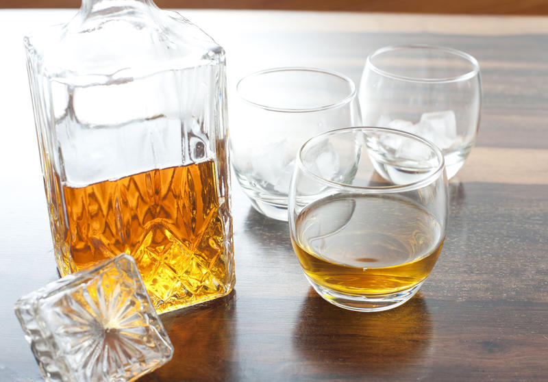A glass liqour decanter with whiskey or similar inside and a glass