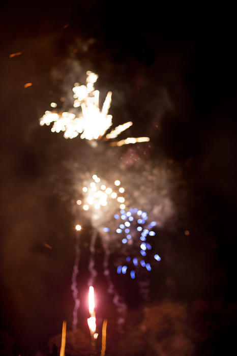 Colorful defocused fireworks background with a bokeh of red, white and blue sparks from bursting rockets in a night sky during a festive celebration